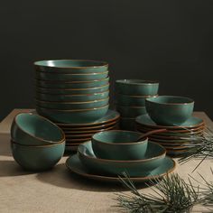 a table topped with lots of green plates and bowls