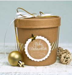 there is a small christmas ornament next to a brown container with a tag on it