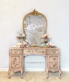 an antique vanity with a mirror and candles on it in front of a white wall