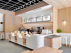 the interior of a coffee shop with white counter tops and wood paneling on the walls