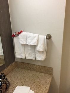 towels are hanging on the towel rack in this hotel bathroom, and one is folded up