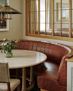 a corner table with two chairs and a bench