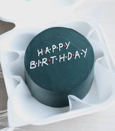 a birthday cake with the words happy birthday written on it sitting in an egg carton