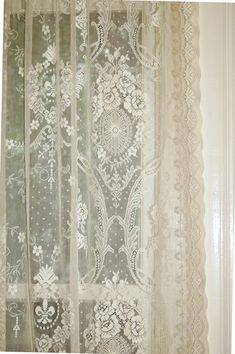 an open window with white lace on it