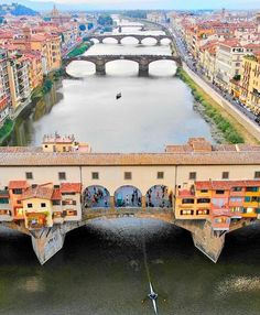 an aerial view of a bridge over a body of water with buildings on both sides