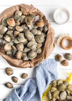 clams in a paper bag next to some other items on a white wooden table