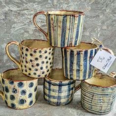 a stack of blue and white coffee mugs sitting next to each other on top of a table