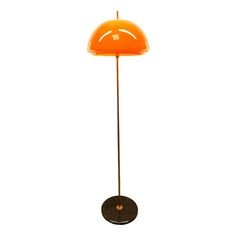 an orange floor lamp with a black base and a yellow shade on the top, against a white background