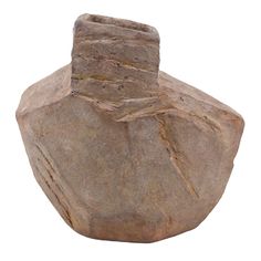 a stone vase sitting on top of a white surface