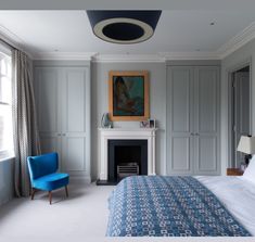 a bedroom with a blue chair and fireplace