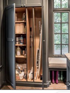 an open cabinet in a kitchen next to a window