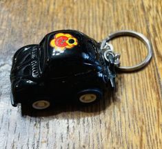 a black car shaped keychain sitting on top of a wooden table