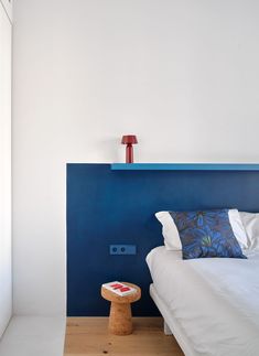 a white bed sitting next to a blue headboard