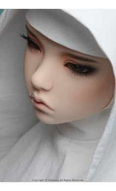 a mannequin's head wearing a white hoodie and black eyeliners