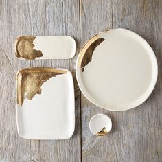 two white plates with gold paint on them