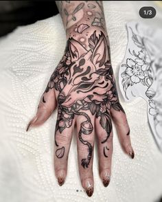 a person's hand with tattoos on it