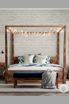 a bedroom with a bed, nightstands and pillows on the floor next to a white brick wall