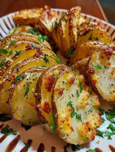 baked potato wedges on a plate with parmesan cheese and herbs sprinkled on top