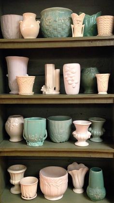 many different vases and bowls are on shelves