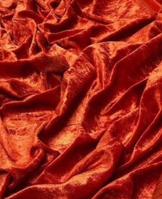 an orange cloth is laying on top of a wooden table and it looks like the fabric has been dyed red