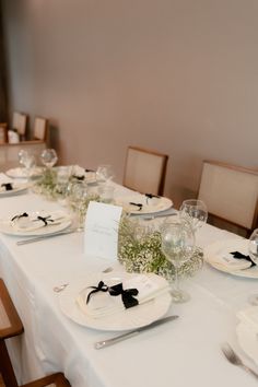 the table is set with white plates and silverware