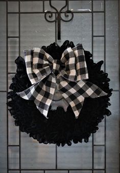 a black and white wreath with a bow