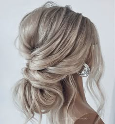 a woman with blonde hair in a half updo, wearing an elegant hairstyle