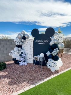 a mickey mouse balloon arch with balloons in the shape of minnie's ears on it