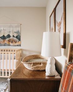 a baby's room with a crib, rocking chair and lamp