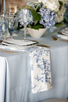 the table is set with blue and white flowers