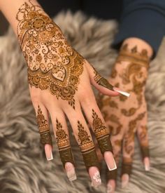 a woman's hands with henna tattoos on them