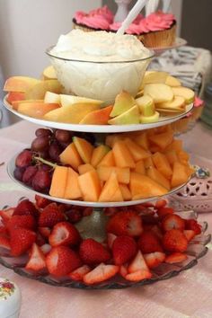 three tiered trays filled with fruit and cupcakes