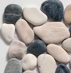 several different colored rocks on a white surface