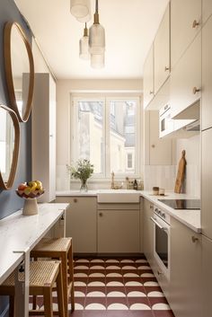 a kitchen with white cabinets and brown flooring