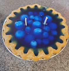 a blue and yellow dish with candles in it