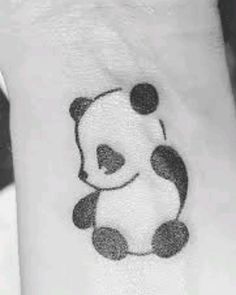 a small panda bear tattoo on the wrist