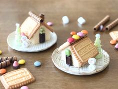 some cookies and candies are sitting on the table next to small houses with candy in them