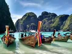 there are many boats that are in the water near each other on the ocean shore