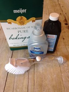 a bottle of soap, toothpaste and other items on a wooden floor next to a box