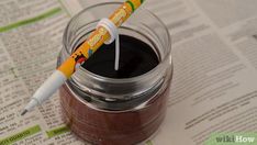 a glass jar filled with chocolate pudding and a toothbrush sticking out of the top