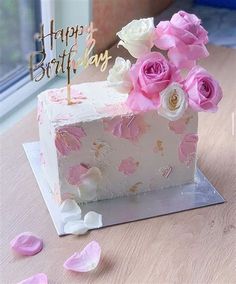 a birthday cake decorated with pink flowers on a table