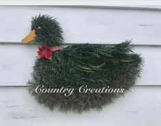 a duck made out of grass with a poinsettia on it's head