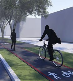 a man riding a bike down a street next to a person on a bicycle path