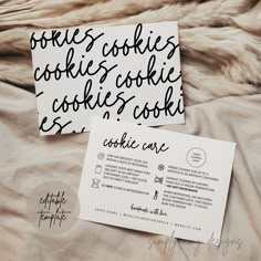 two cookies are sitting on top of a bed next to a card with the words cookie's cookies cookie and cookie's cookies cookie