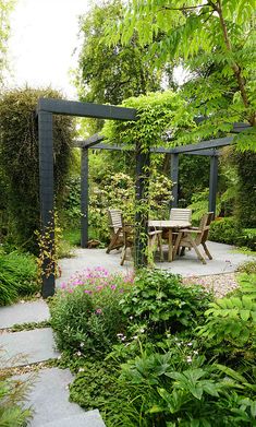 an outdoor dining area in the middle of a garden