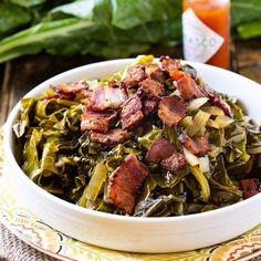 a white bowl filled with bacon and collard greens