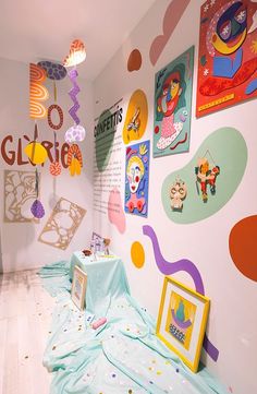 an art gallery with colorful paintings and pictures on the wall, including children's artwork