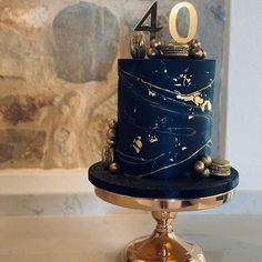 a blue and gold cake with the number forty on top