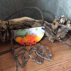 a piece of metal sitting on top of a wooden table next to some branches and twigs