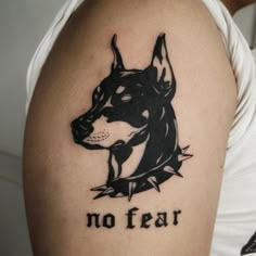 a man with a dog tattoo on his arm that says no fear in black ink